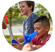 Two young scouts holding model rockets smiling while waiting for their turn to launch